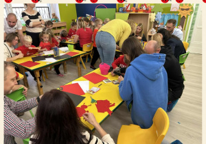 Rodzice wraz z dziećmi wykonują pracę plastyczną