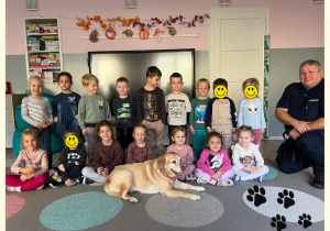 Dzieci z grupy II pozują do zdjęcia z psem i jego opiekunem