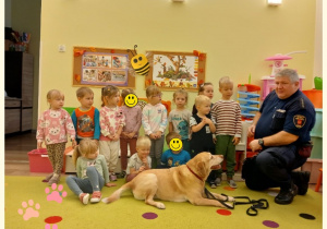 Dzieci z grupy I pozują do zdjęcia z psem i jego opiekunem