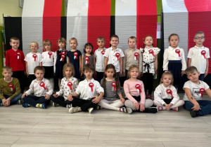 Dzieci pozują na tle barw narodowych Polski