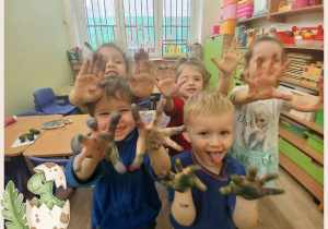 Dzieci pozują z pomalowanymi dłońmi