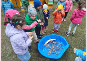 Dzieci wrzucają do wody części stroju Marzanny